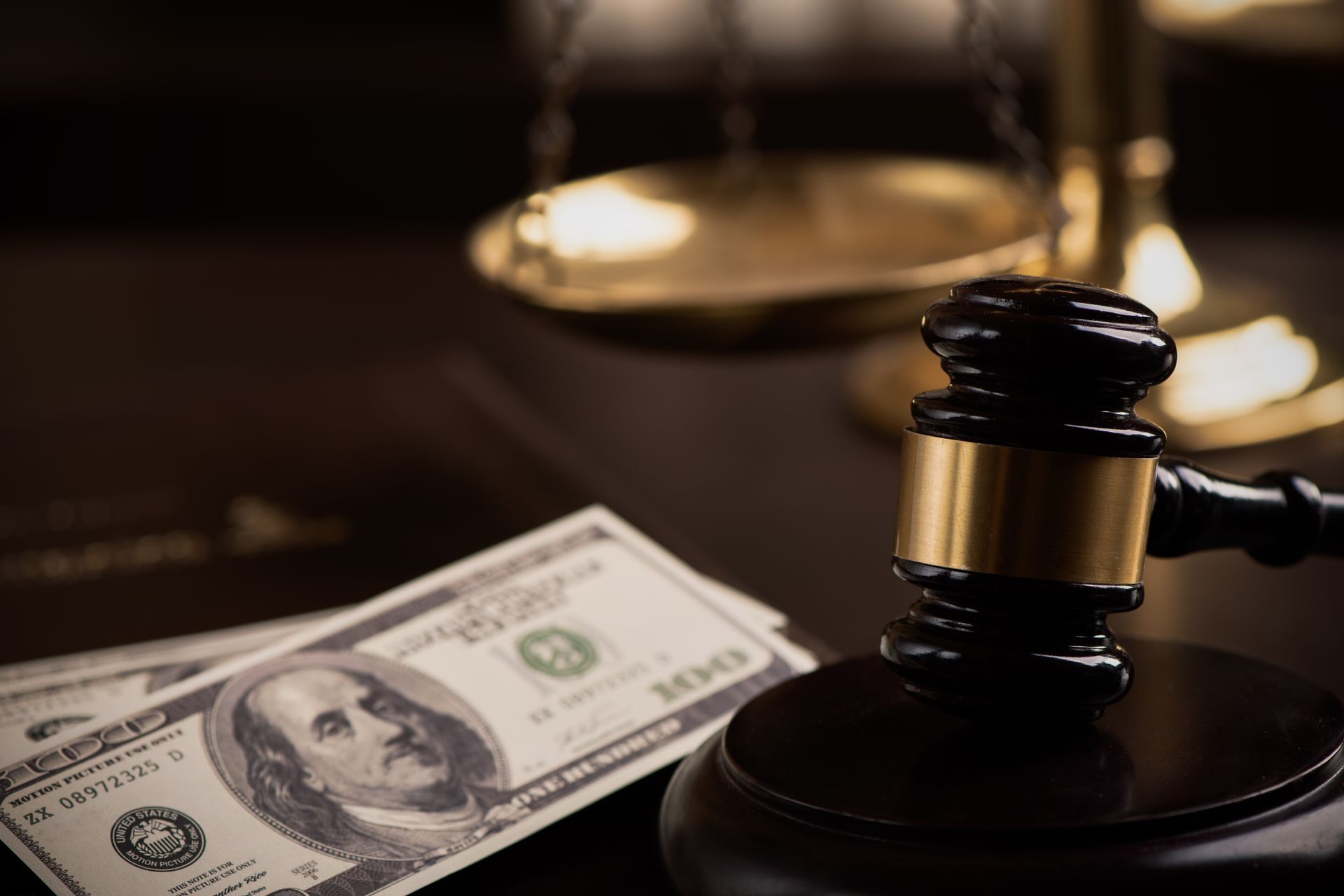Gavel next to American money and a scale, suggesting a legal or financial context.