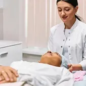 Dental professional examining a patient in a bright clinic room
