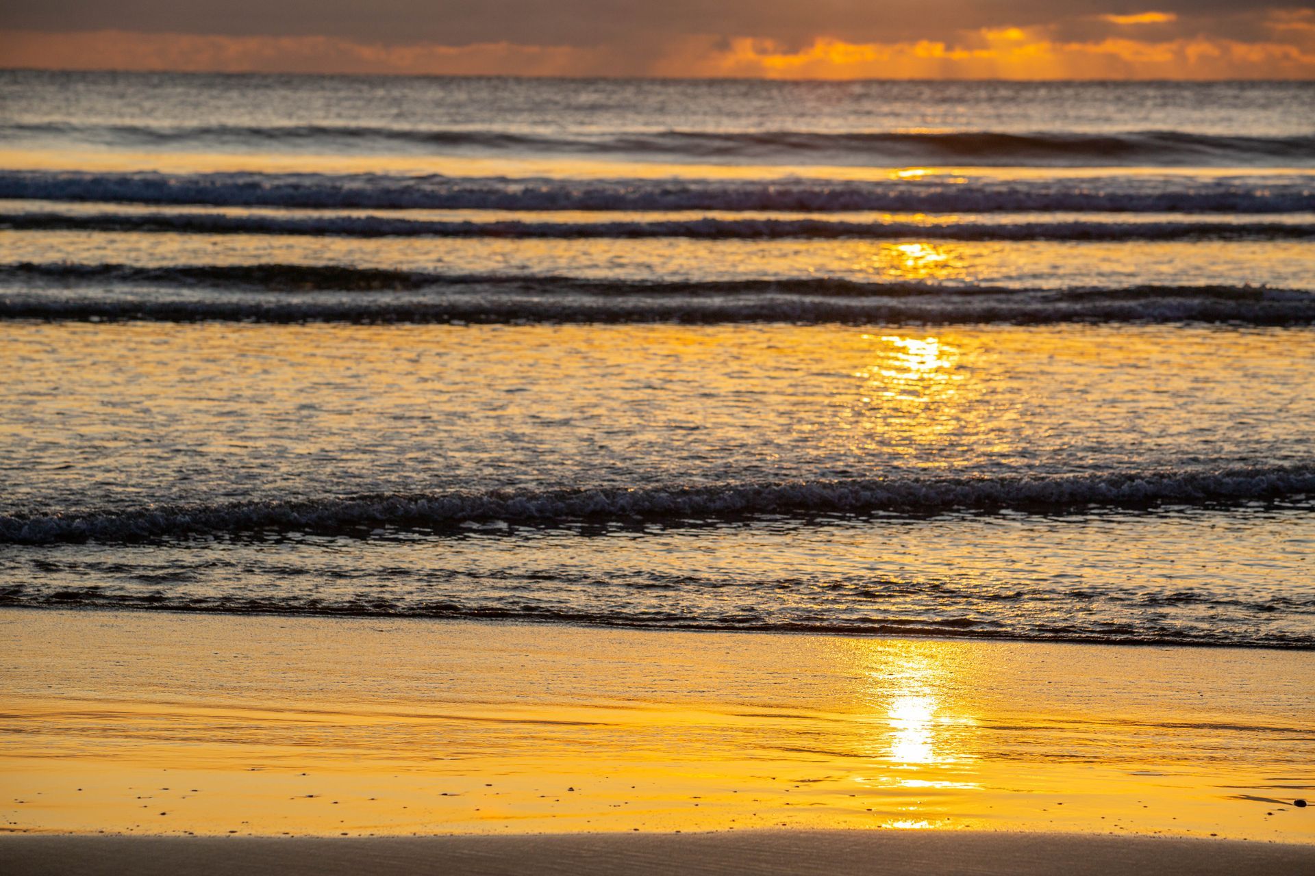 Sunset Over Calm Ocean Waves, with Golden Light Reflecting on The Water and Shore — Timeless Funerals in Macquarie Park, NSW