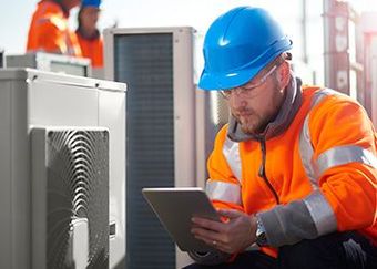 Man Checking HVAC — Atlantic, IA — Camblin Mechanical Inc Man Checking HVAC — Atlantic, IA — Camblin Mechanical Inc