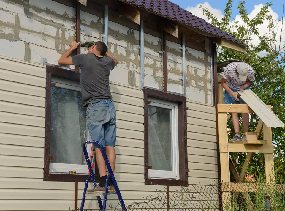 a man is installing tiles on a wall in a bathroom .