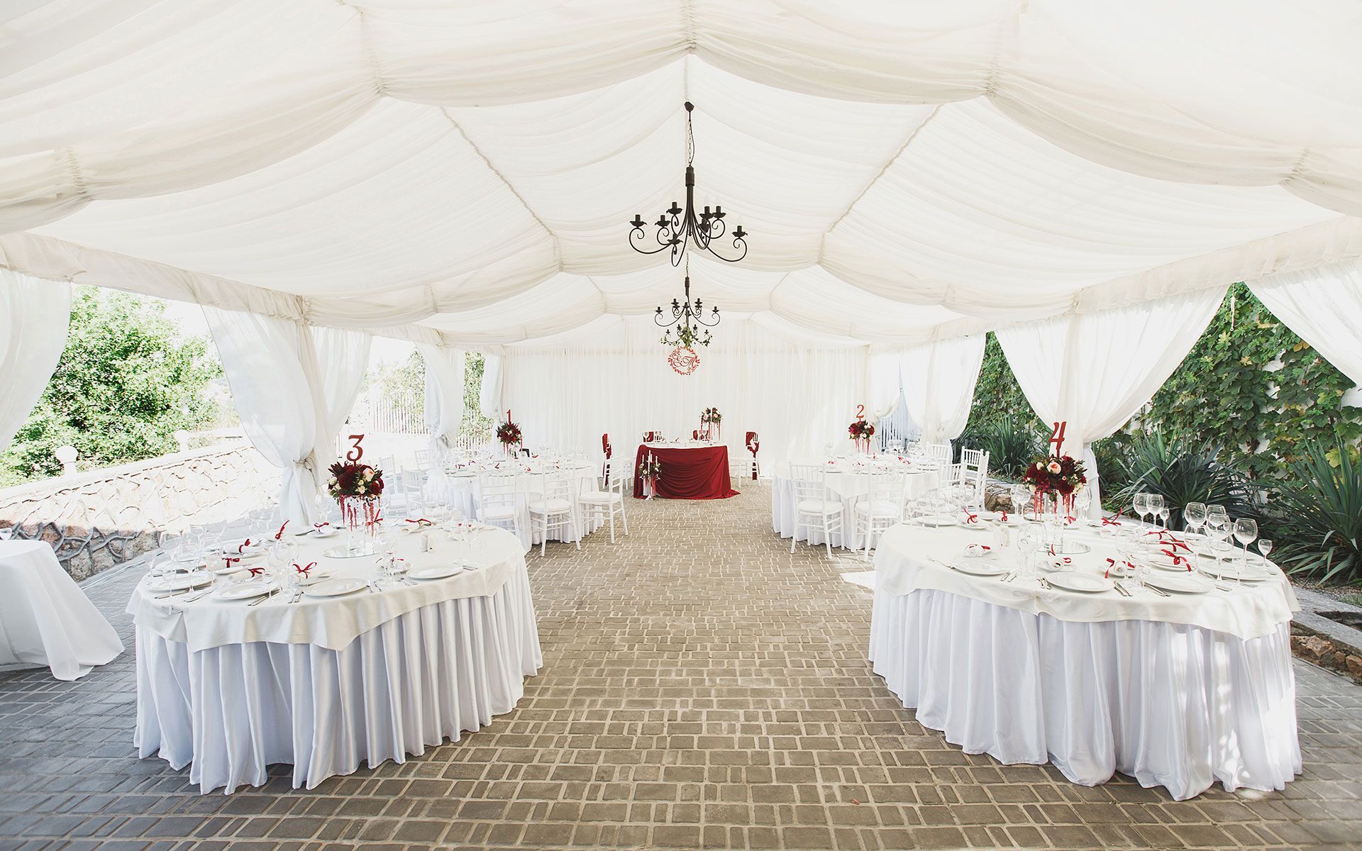A large white tent with tables and chairs underneath it.