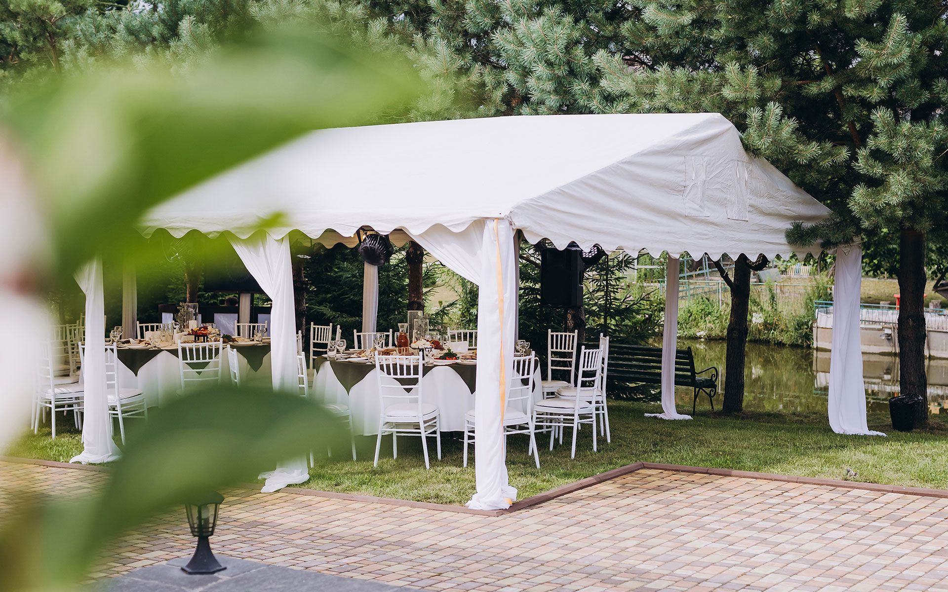 A white tent with tables and chairs underneath it.