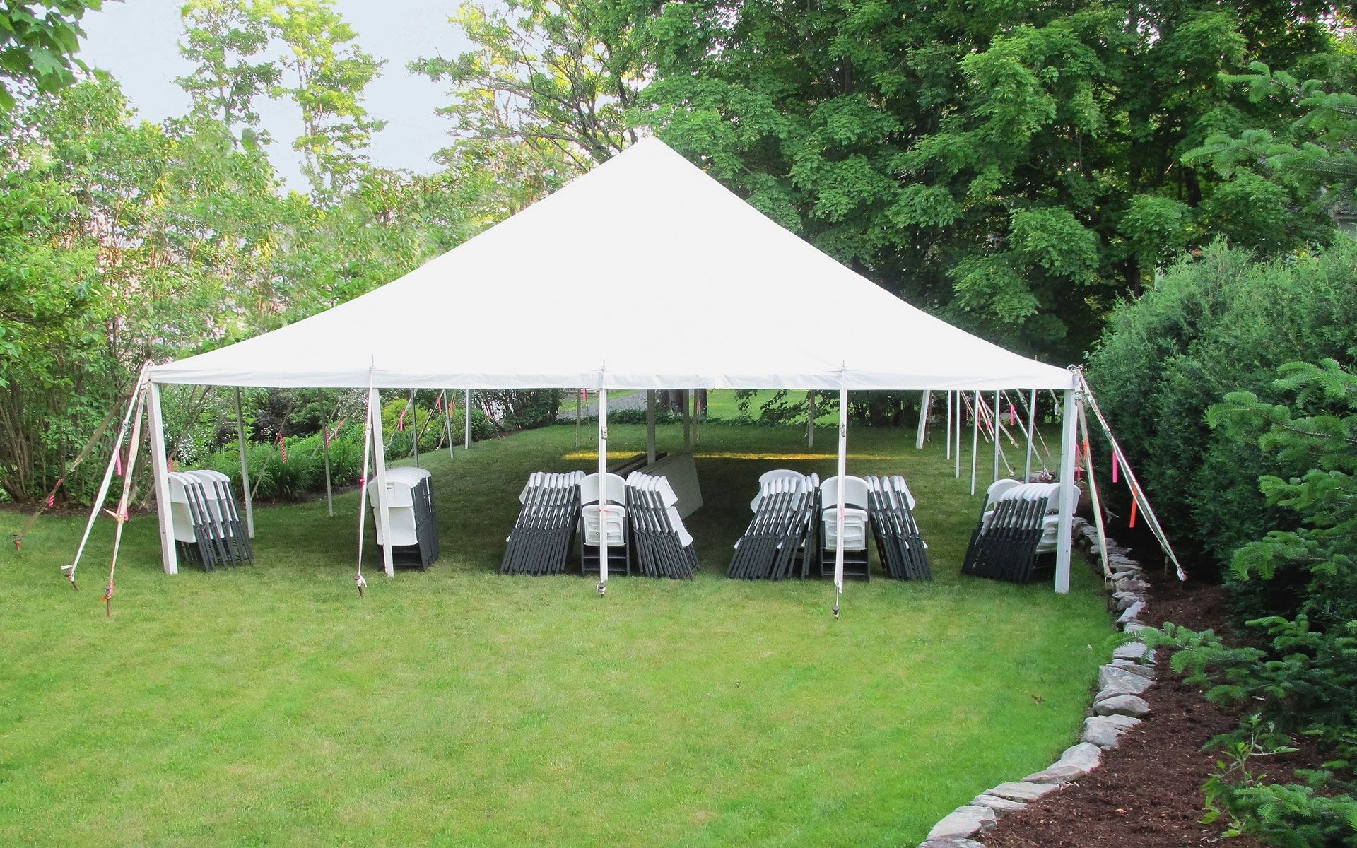 A large white tent with tables and chairs underneath it