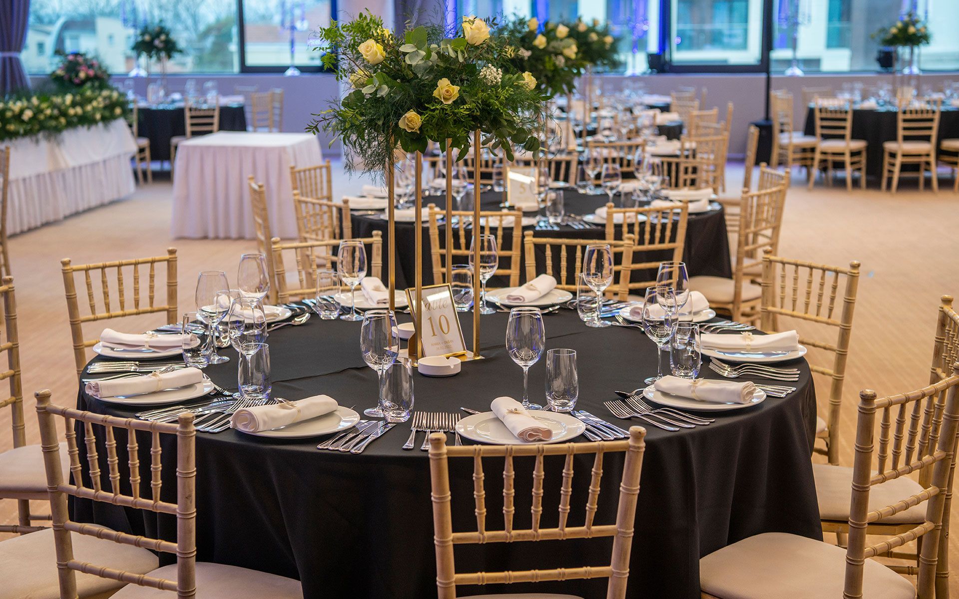 A large room with tables and chairs set up for a wedding reception.