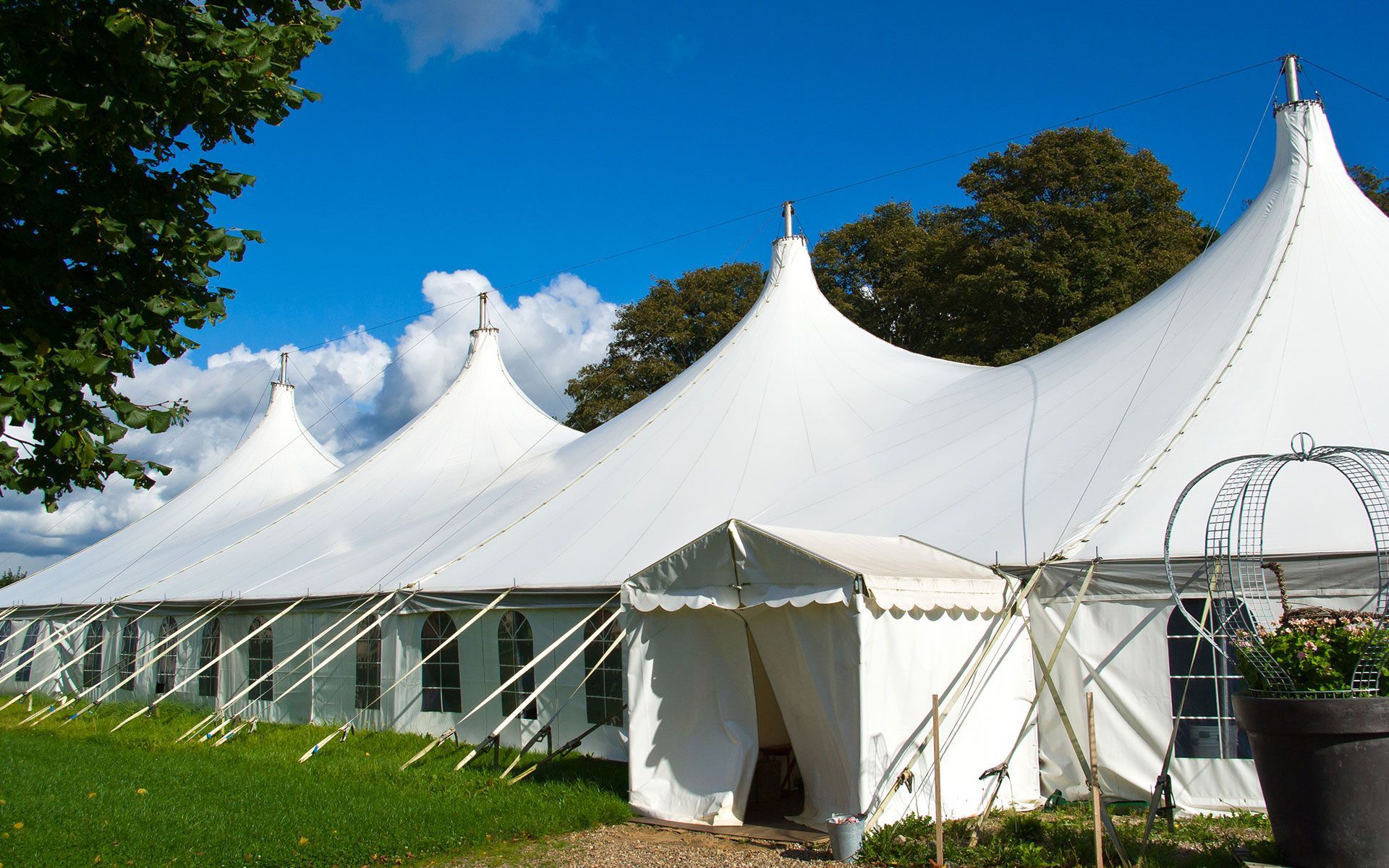 A large white tent is sitting in the middle of a grassy field