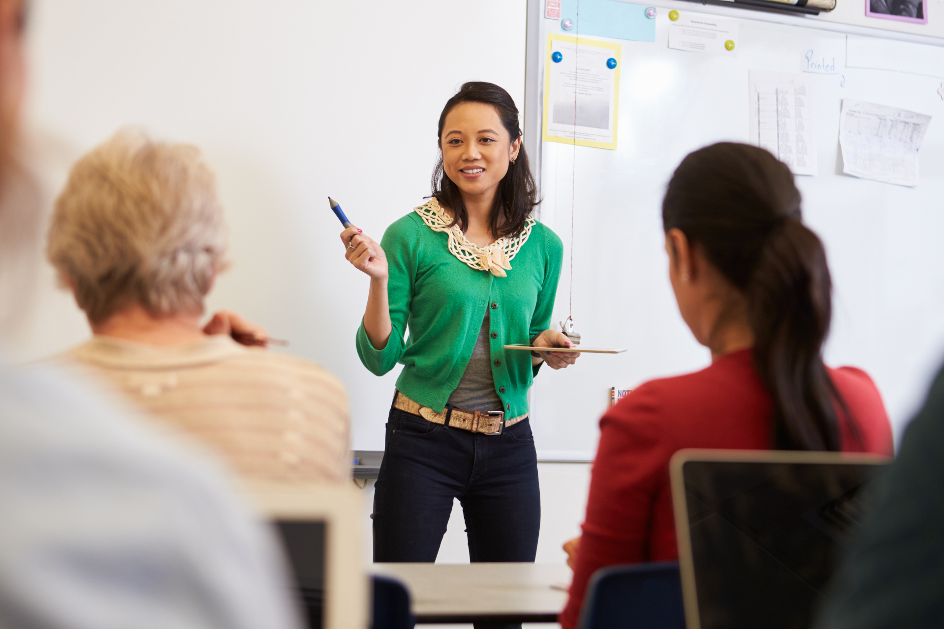 A woman is giving a presentation to a group of people in a classroom.