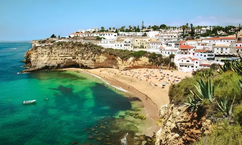 A cove beach in the Algarve with cliffs and clear water