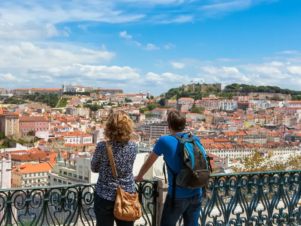 Two travellers looking out over the rooftops of Lisbon