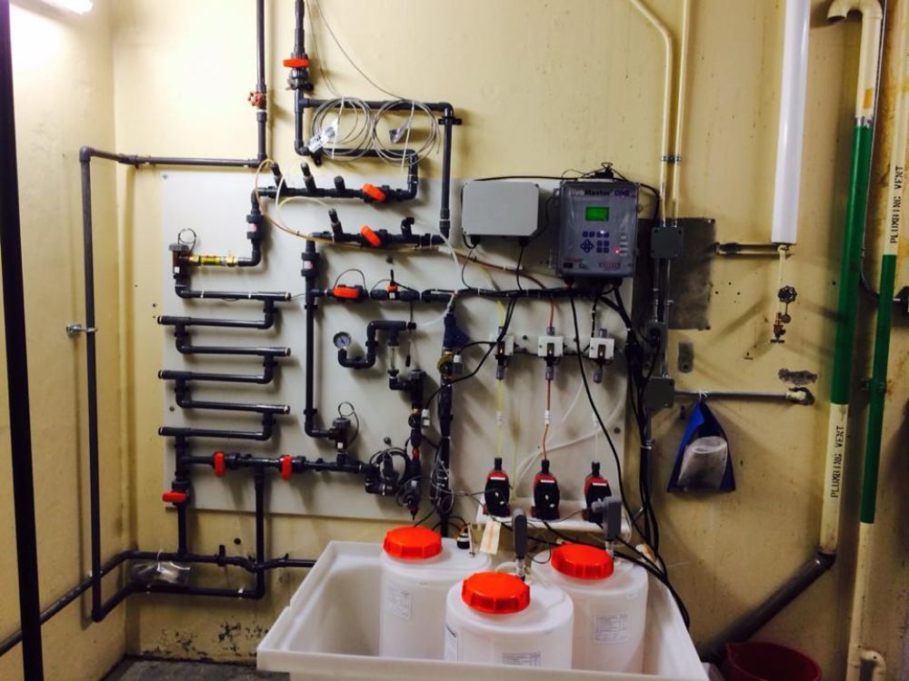 A wall with a bunch of pipes and containers on it