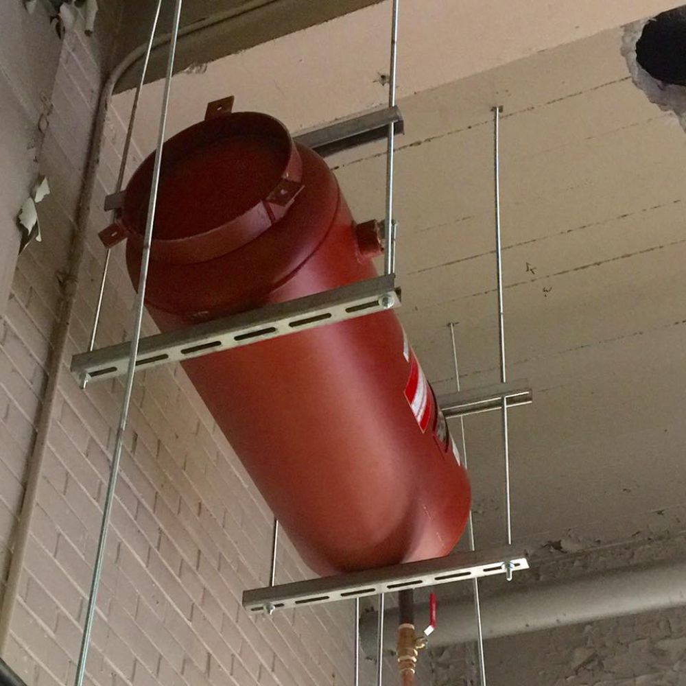 A large red tank is hanging from the ceiling