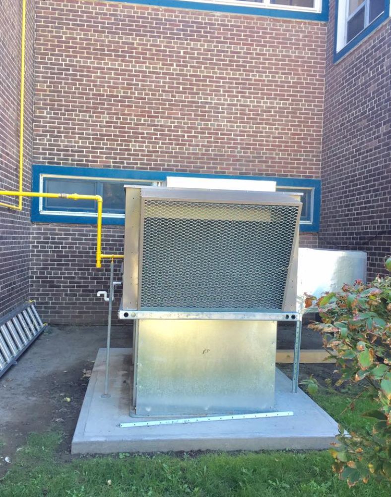 A brick building with a metal box in front of it