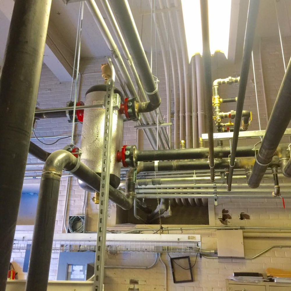 A room with a lot of pipes hanging from the ceiling
