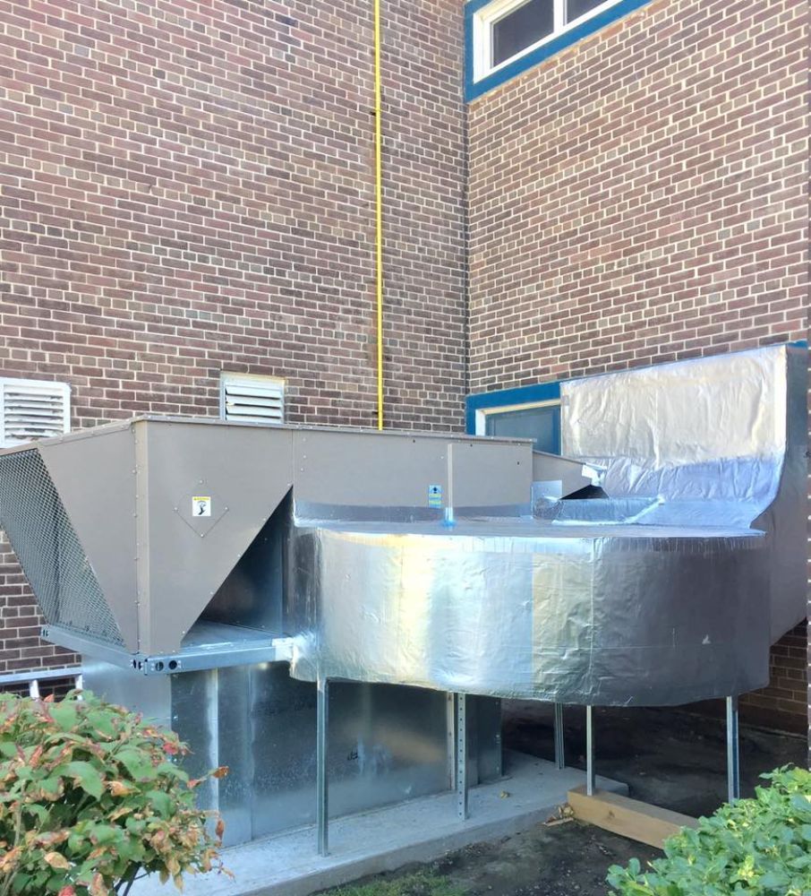 A brick building with a large metal structure in front of it