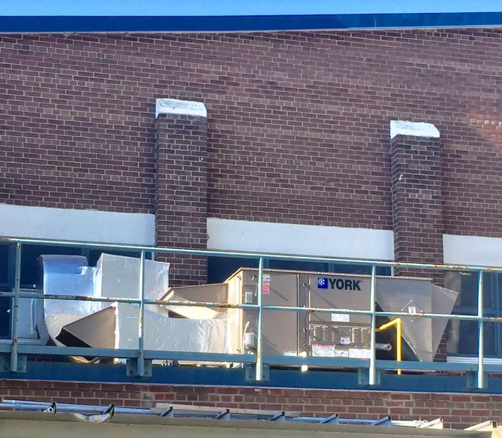 A york air conditioner is on the side of a brick building