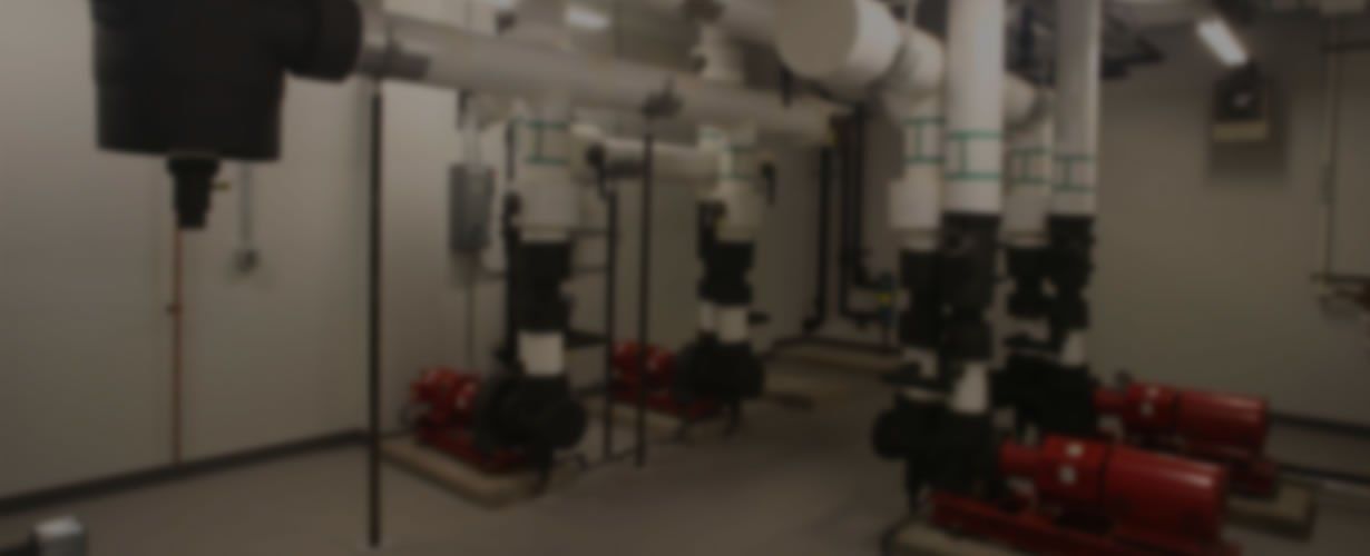 A blurred image of a room filled with pipes and pumps.