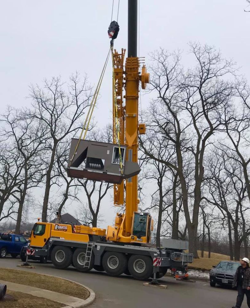 A large yellow truck with a crane attached to it