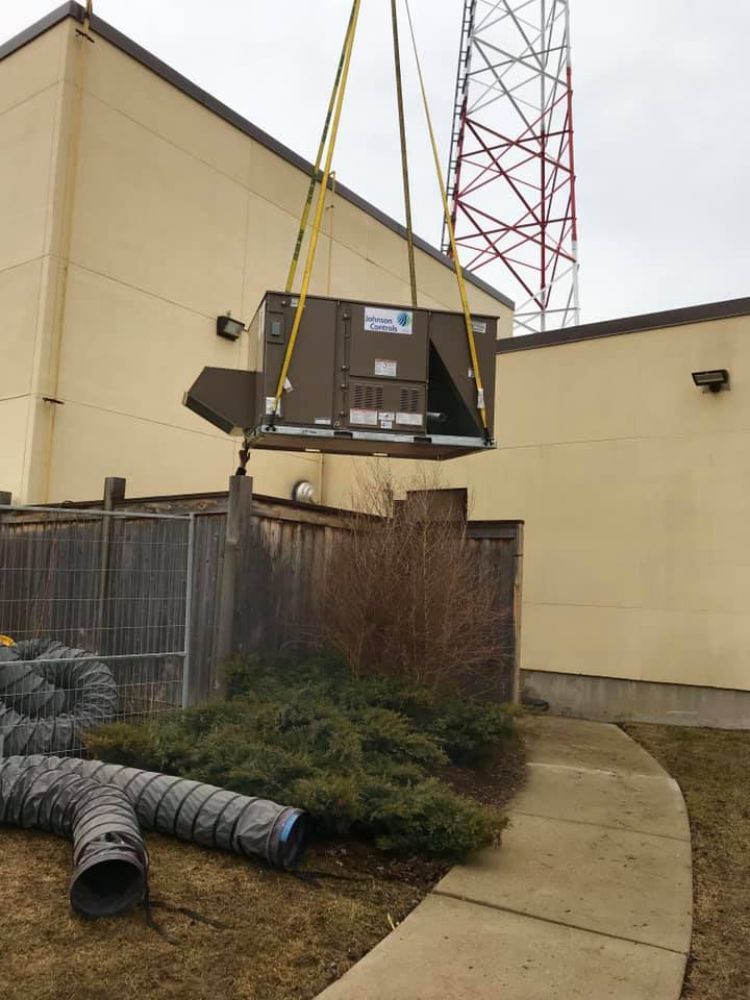 A large piece of equipment is being lifted by a crane.