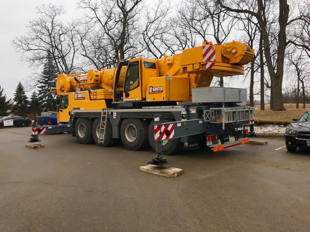 A large yellow crane is parked in a parking lot.