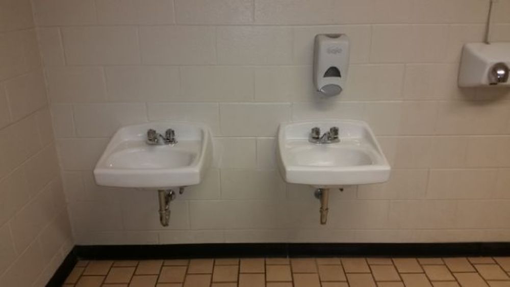 Two white sinks in a bathroom next to each other.