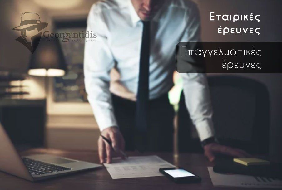 Άνδρας με κοστούμι στέκεται σε ένα γραφείο με χαρτιά, ένα λάπτοπ και ένα τηλέφωνο, και στέλνει μήνυμα: 