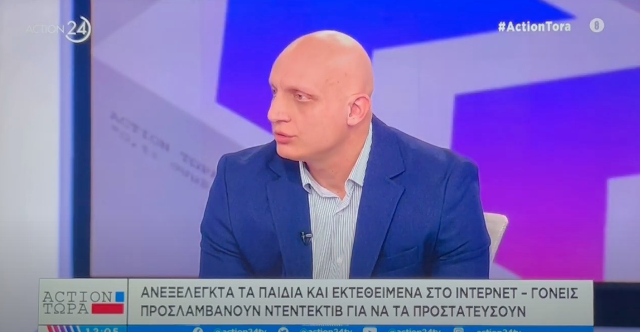 Ένας άντρας με ξυρισμένο κεφάλι και μπλε κοστούμι μιλάει σε τηλεοπτική εκπομπή με κείμενο για τα παιδιά και την ασφάλεια στο διαδίκτυο.