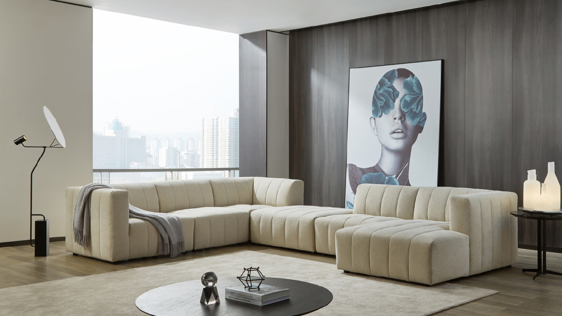 Beige sectional sofa in a modern living room setting with a city view.