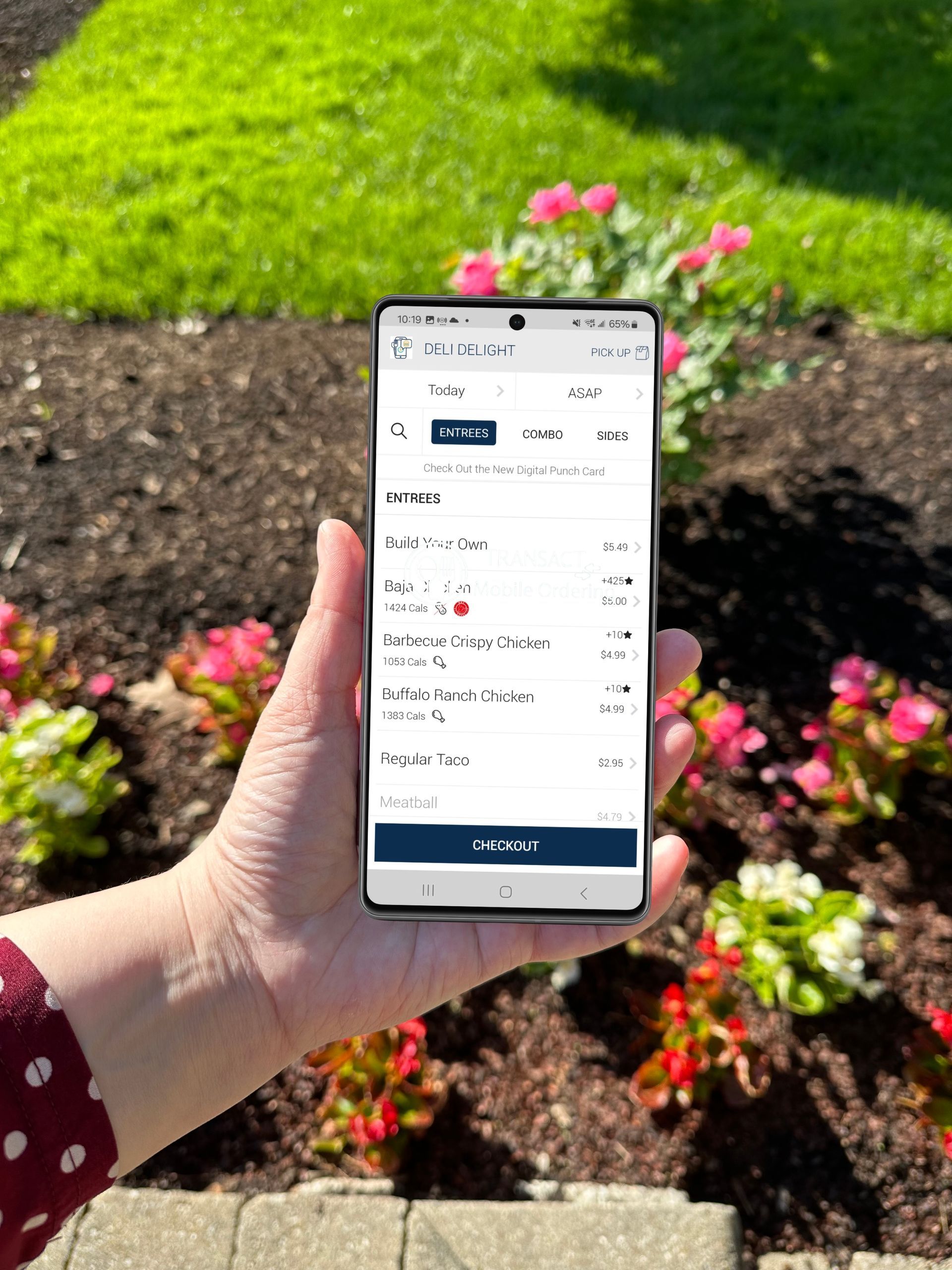 Hand holding a phone displaying a GET app logo against a backdrop of green foliage.