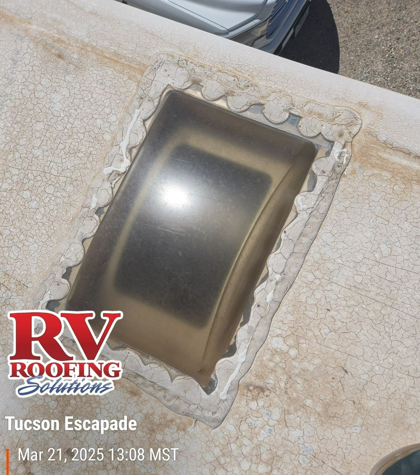 RV skylight on a white roof with sealant damage. Text overlay: