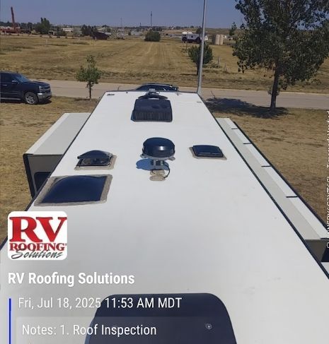 White RV roof with vents and skylights in a rural lot; RV Roofing Solutions logo and date stamp overlay.