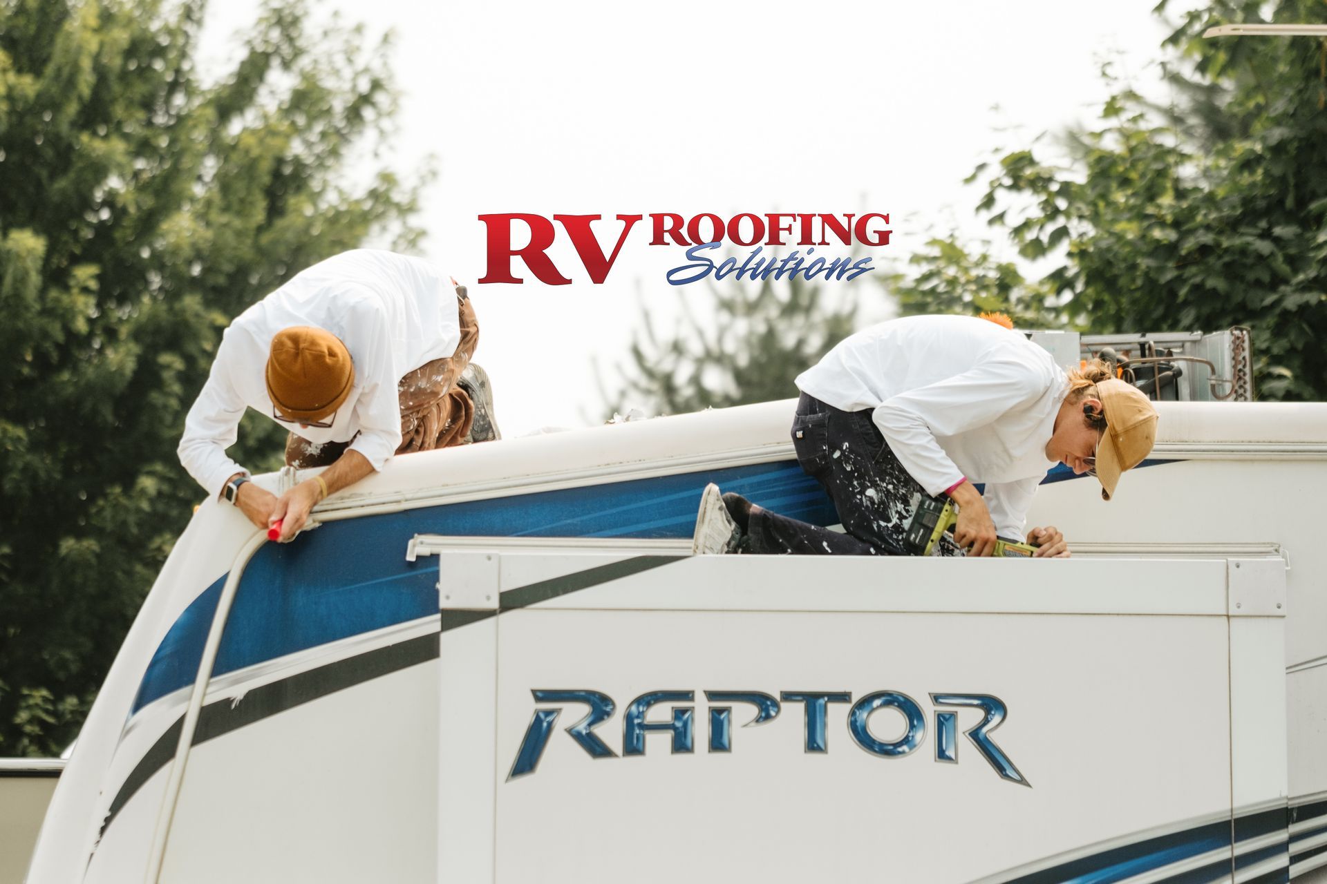 Two people in white shirts work on an RV roof labeled