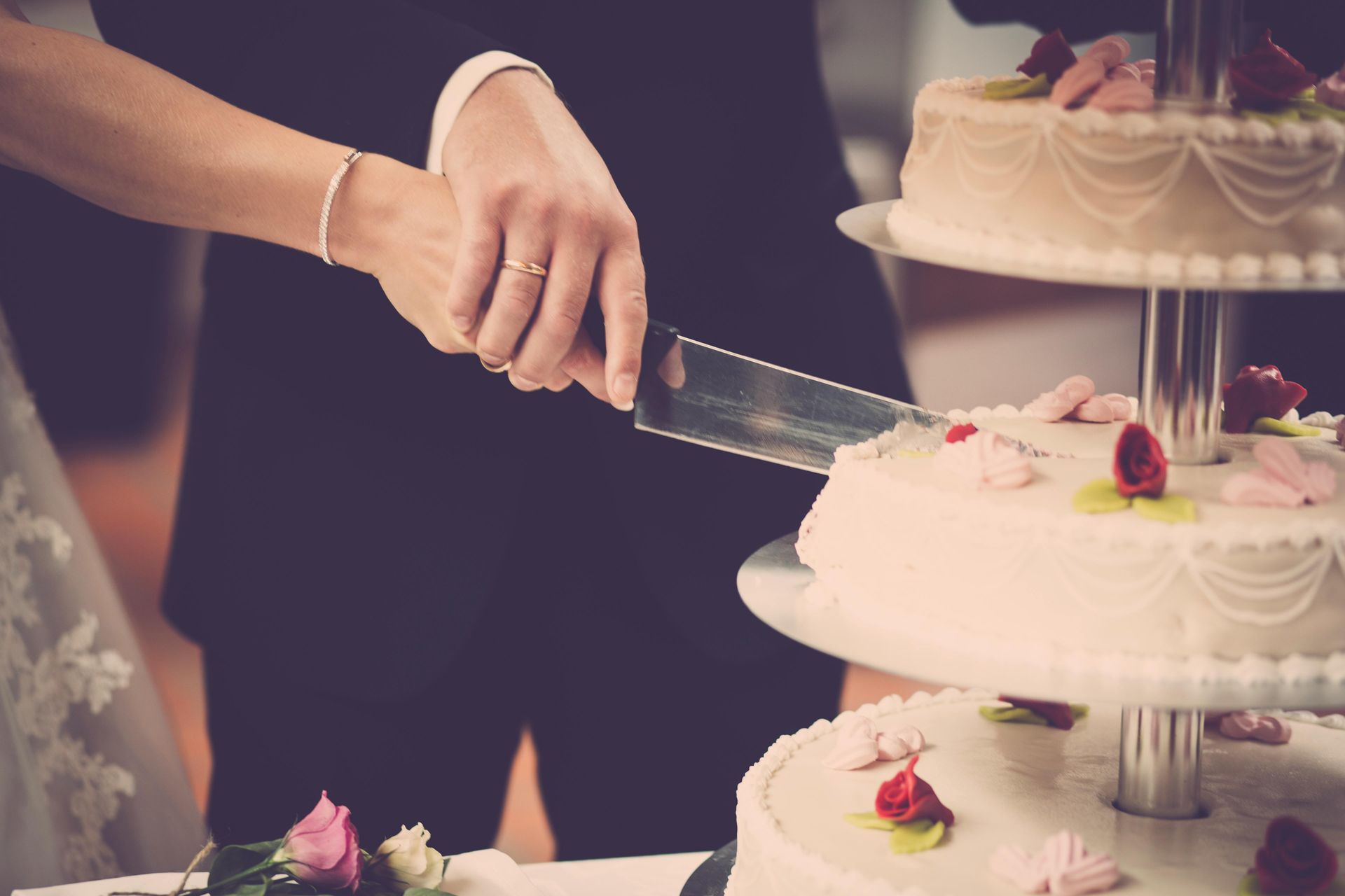 A bride and groom are cutting their wedding cake.
