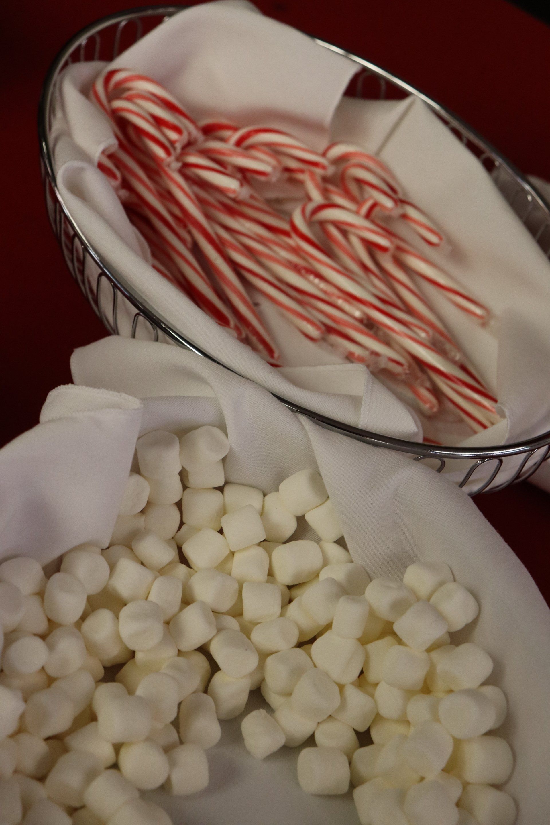 Basket with candy canes and marshmallows, festive treats.