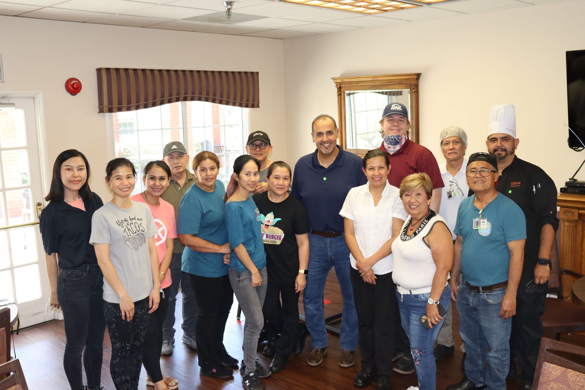 Group photo of diverse people in a room, smiling and posing.