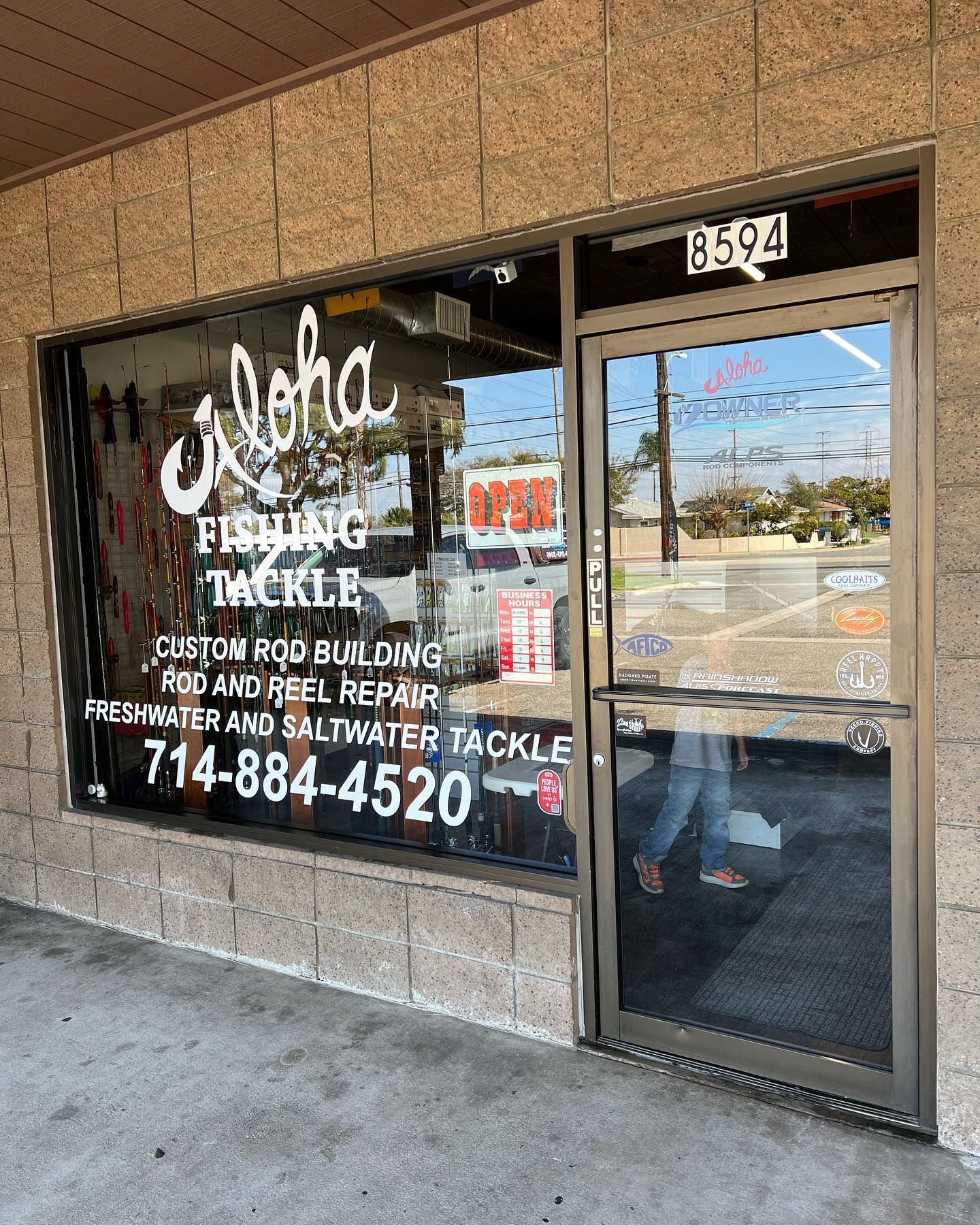 Storefront window and door for Aleka Heating & Air, with business signage and phone number.