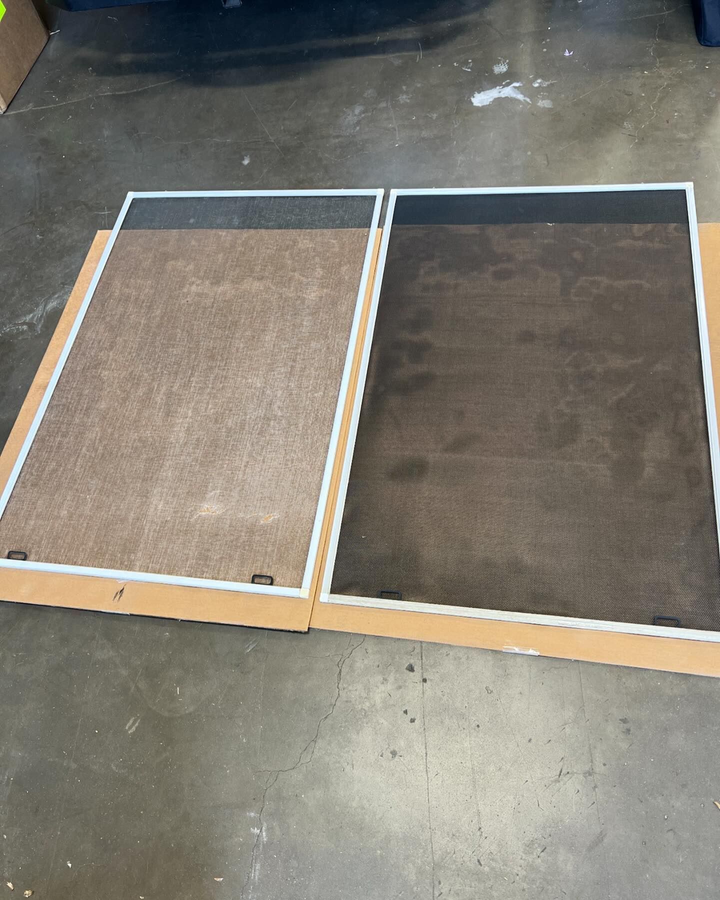 Two floor mats on a concrete floor, one tan and one dark brown, bordered with white tape.