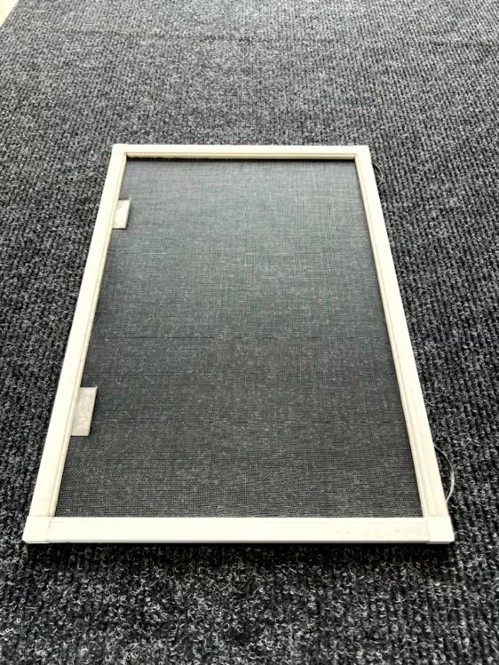White rectangular frame with two small hinges on a dark carpeted floor