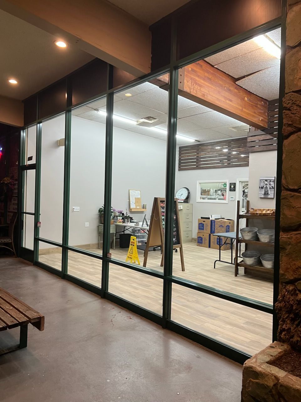 Glass-fronted office with desks, chairs, and wall art inside a bright indoor corridor. Window cleaning experts