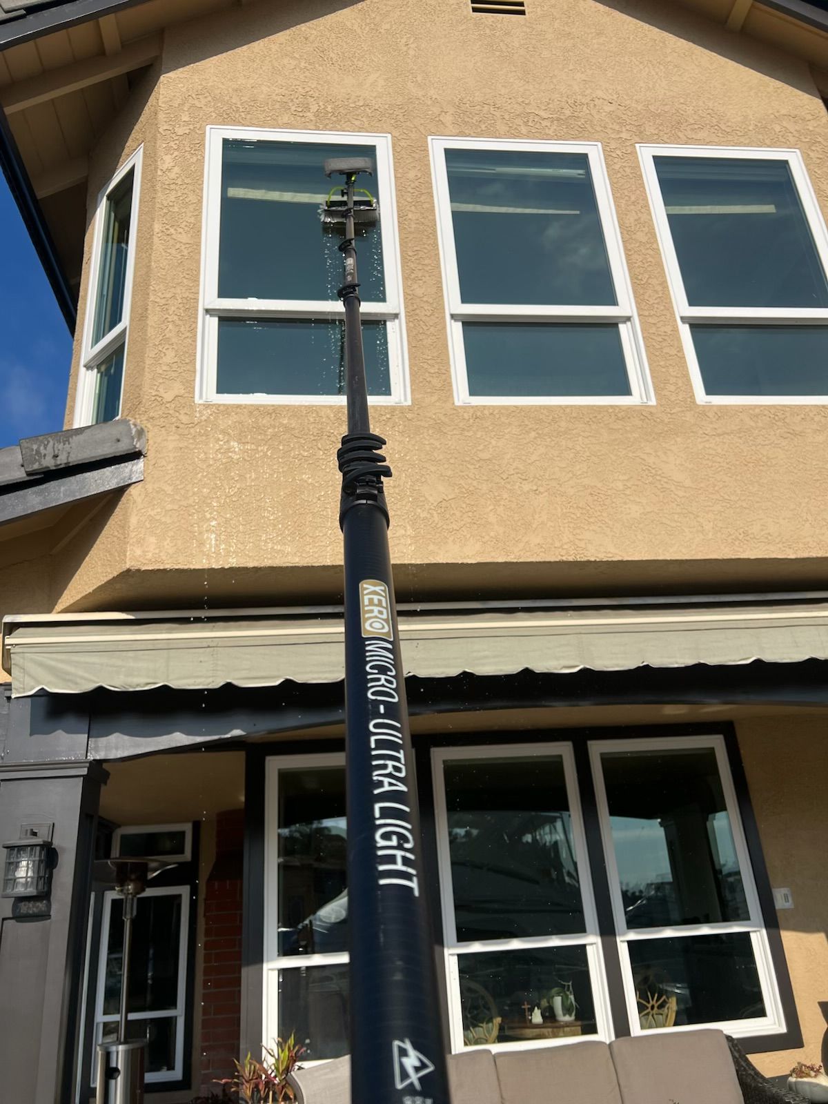 Streetlamp in front of a tan building with white-framed windows and a storefront entrance