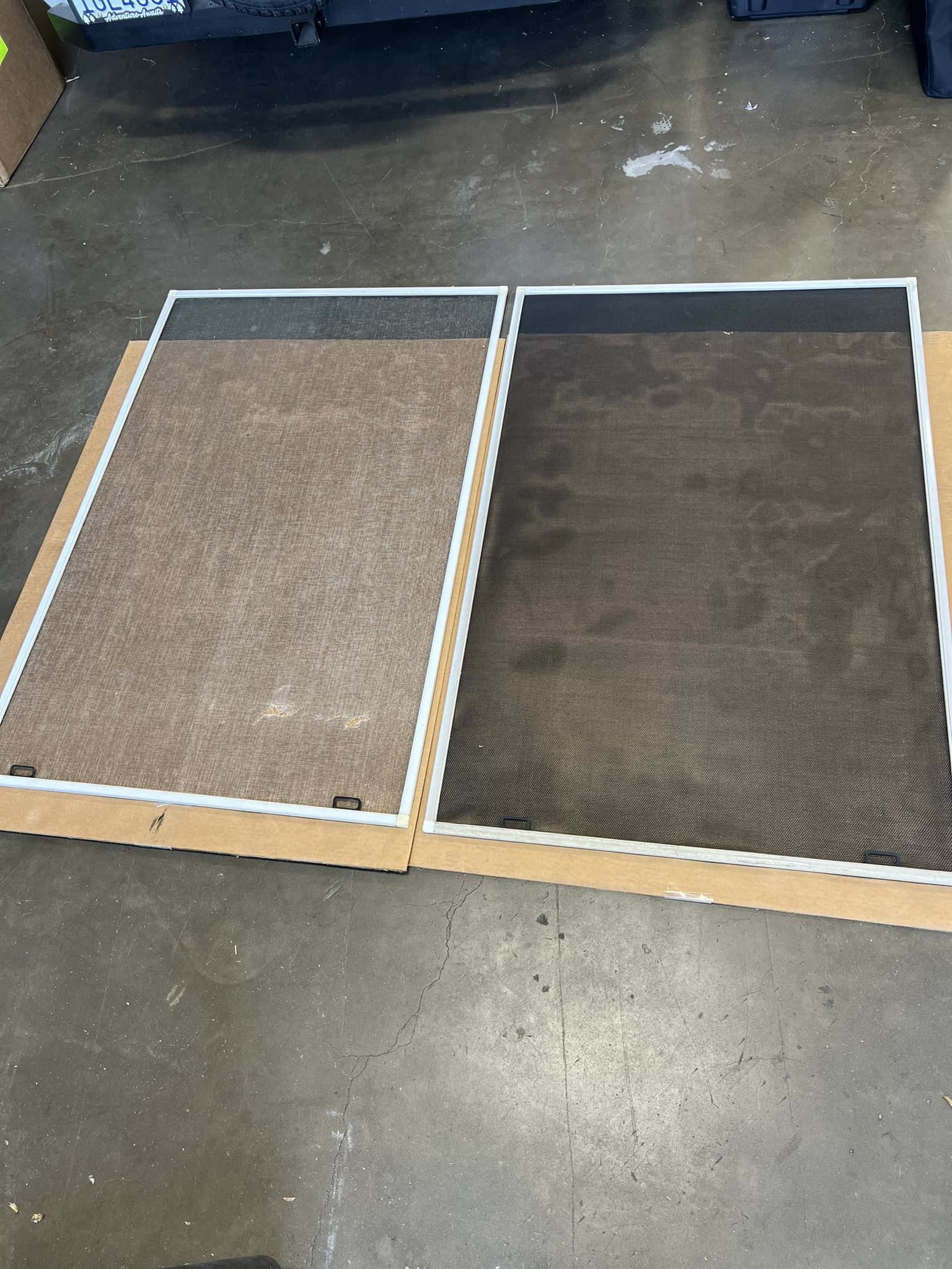Two fabric-covered panels with white frames, side by side on a concrete floor