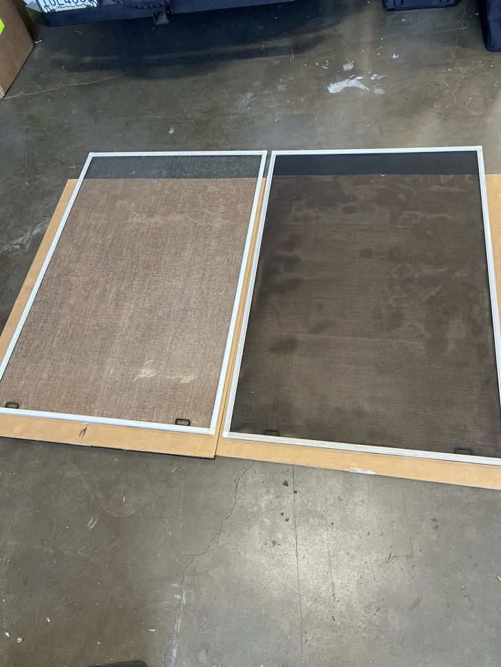 Two carpeted rectangular panels with white frames on a concrete floor, one light brown and one dark brown.