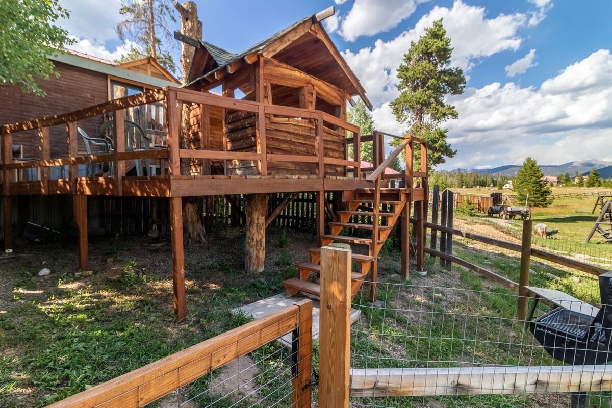 Wooden cabin deck with stairs and railings in a sunny rural landscape