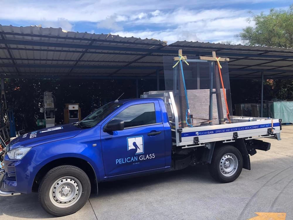 A Blue Pelican Glass Truck Is Parked In Front Of A Building - Glass Replacement in Newcastle, NSW