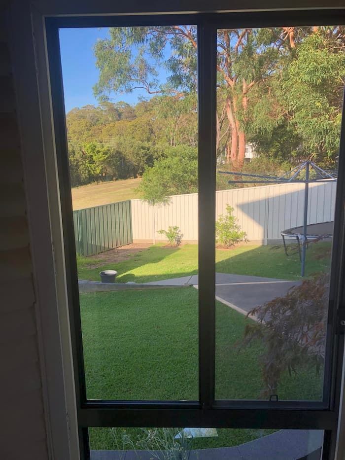A View Of Backyard From A Sliding Window — Pelican Glass in Pelican, NSW