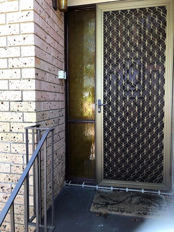 A Brick Building With a Screen Door and Stairs — Pelican Glass in Belmont, NSW