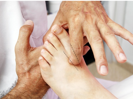 Hands demonstrating a foot massage with pressure points marked on the sole