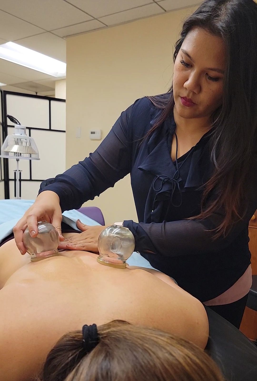 Jessida Putkaew providing cupping for a patient at Rivers of Qi Acupuncture