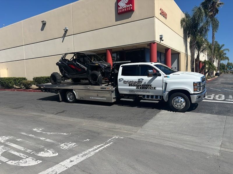 White pickup towing a trailer with a black and red jet ski in a store parking lot