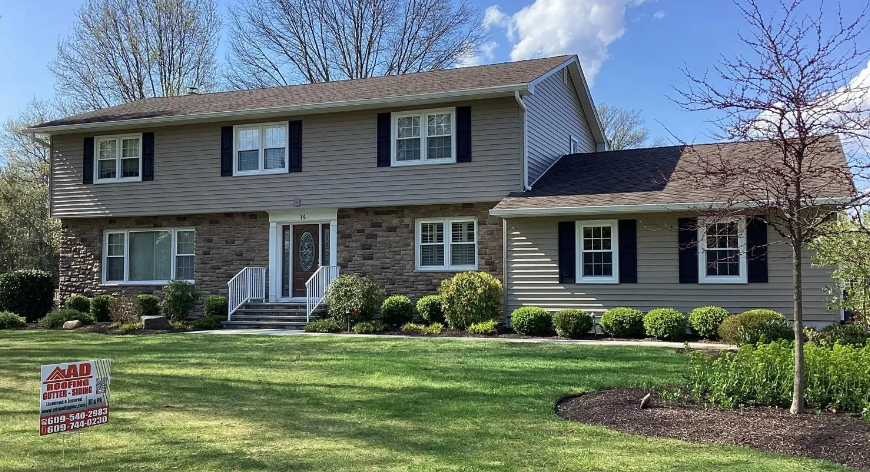 A large house with a lot of windows and black shutters is for sale.