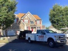 A white truck is parked in front of a large house.